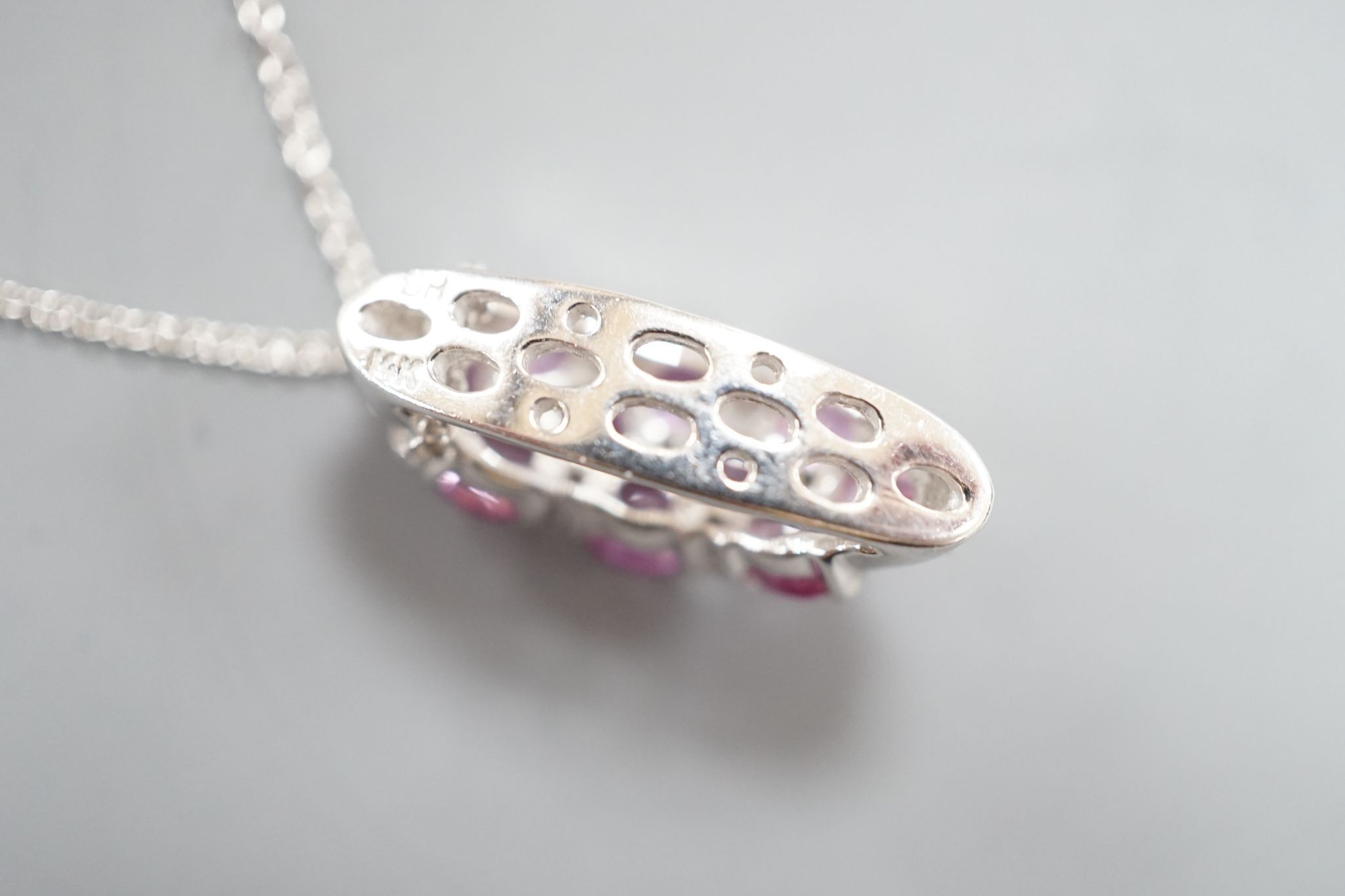 A modern 14k white metal pink sapphire and diamond cluster set pendant, on a 14k fine link chain(knotted)